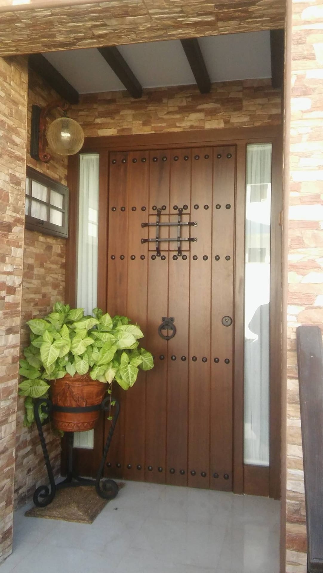 Portón de entrada de madera con clavos y aldaba